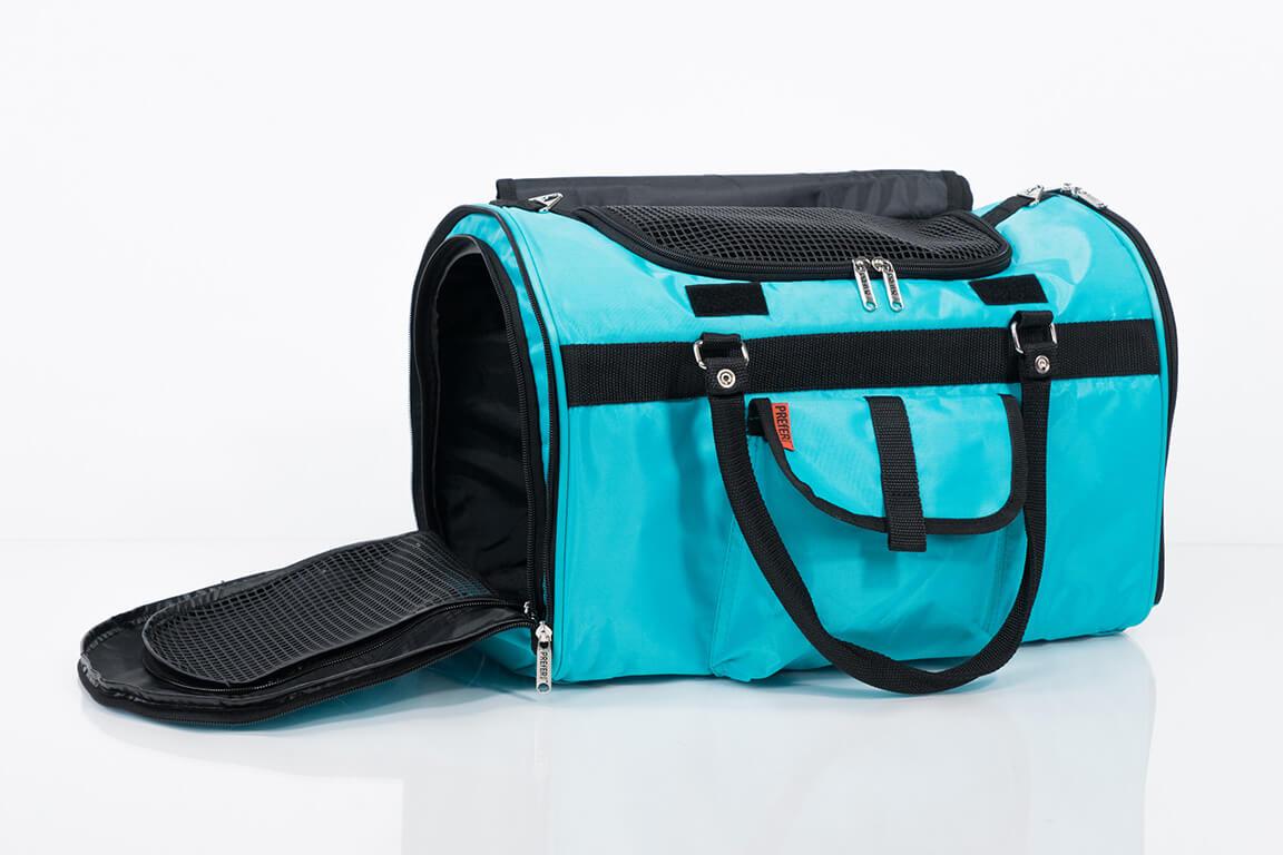 Turquoise pet carrier with black interior and straps on a white background