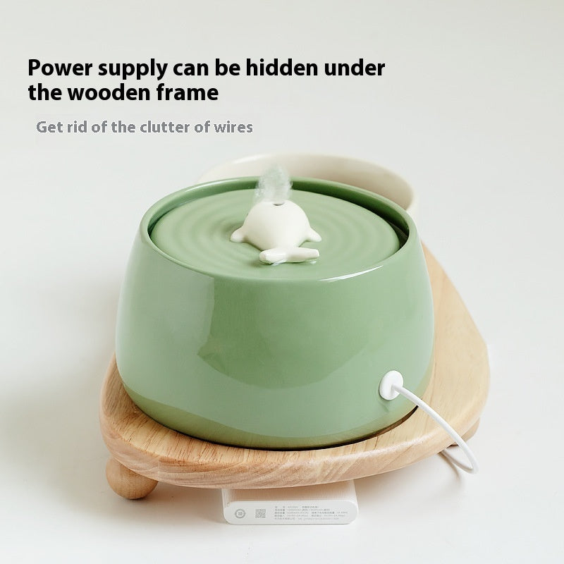 Green ceramic diffuser on a wooden stand with text about power supply concealment.