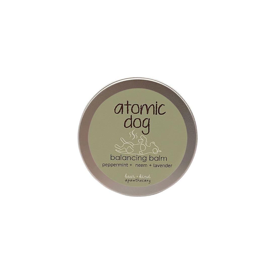 Balancing balm container with 'atomic dog' branding on a white background