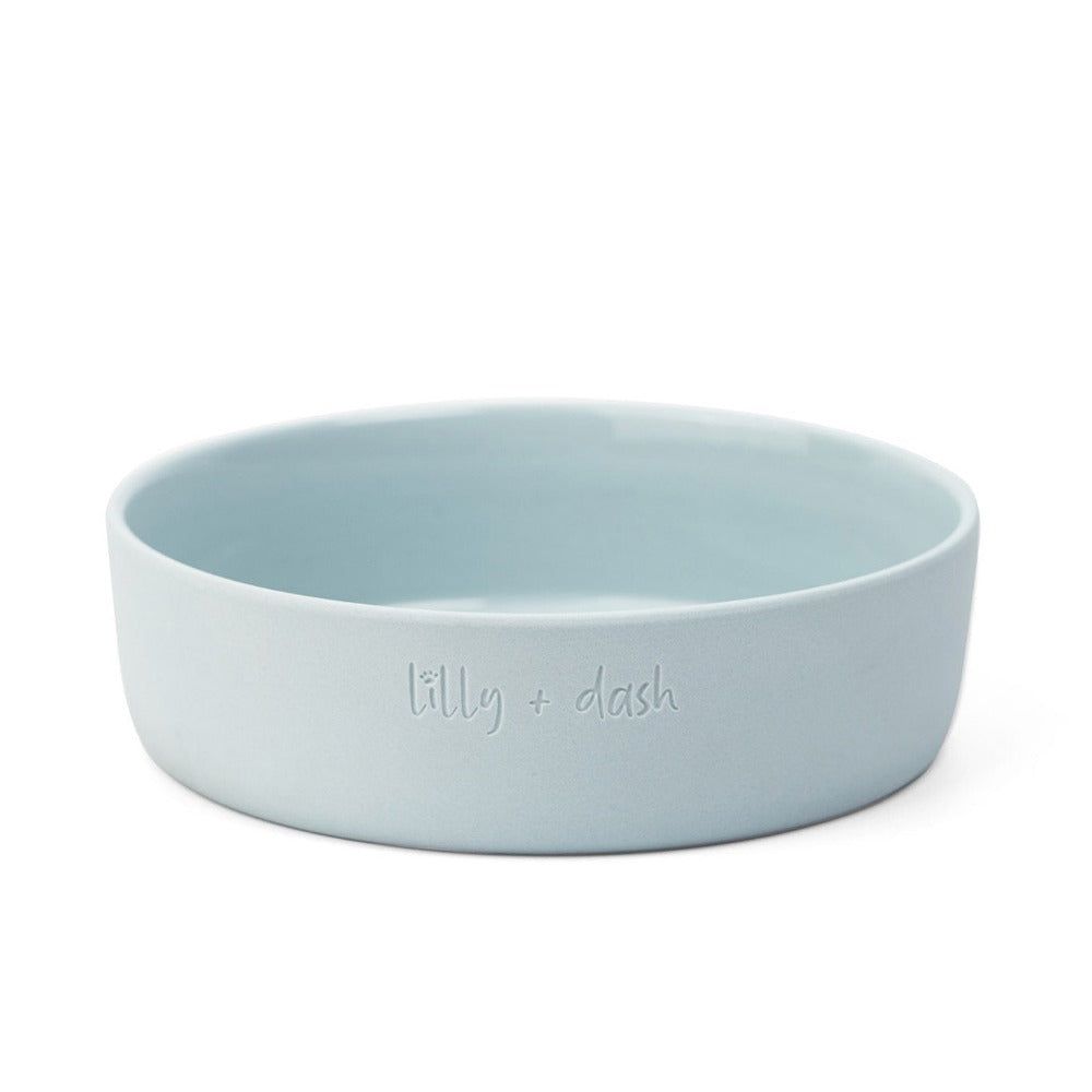 Light blue ceramic bowl with 'lilly + dash' branding on a white background