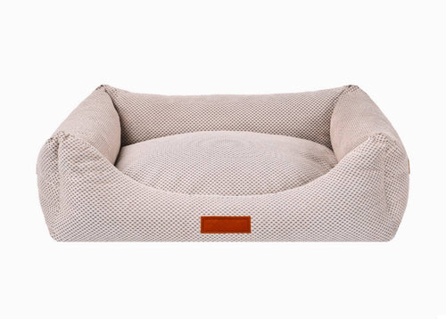 Beige pet bed with a brown label on a white background