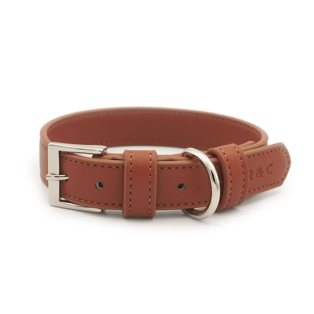 A brown leather dog collar with silver-tone metal hardware, including a buckle, D-ring, and eyelets, shown on a plain white background. The brand name 'L & C' is embossed on the side.