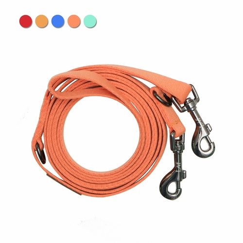 Coiled orange dog leash with metal hooks on a white background