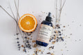 Bottle of 'Furry Friends Fur Refresher' with an orange slice and dried herbs on a light background