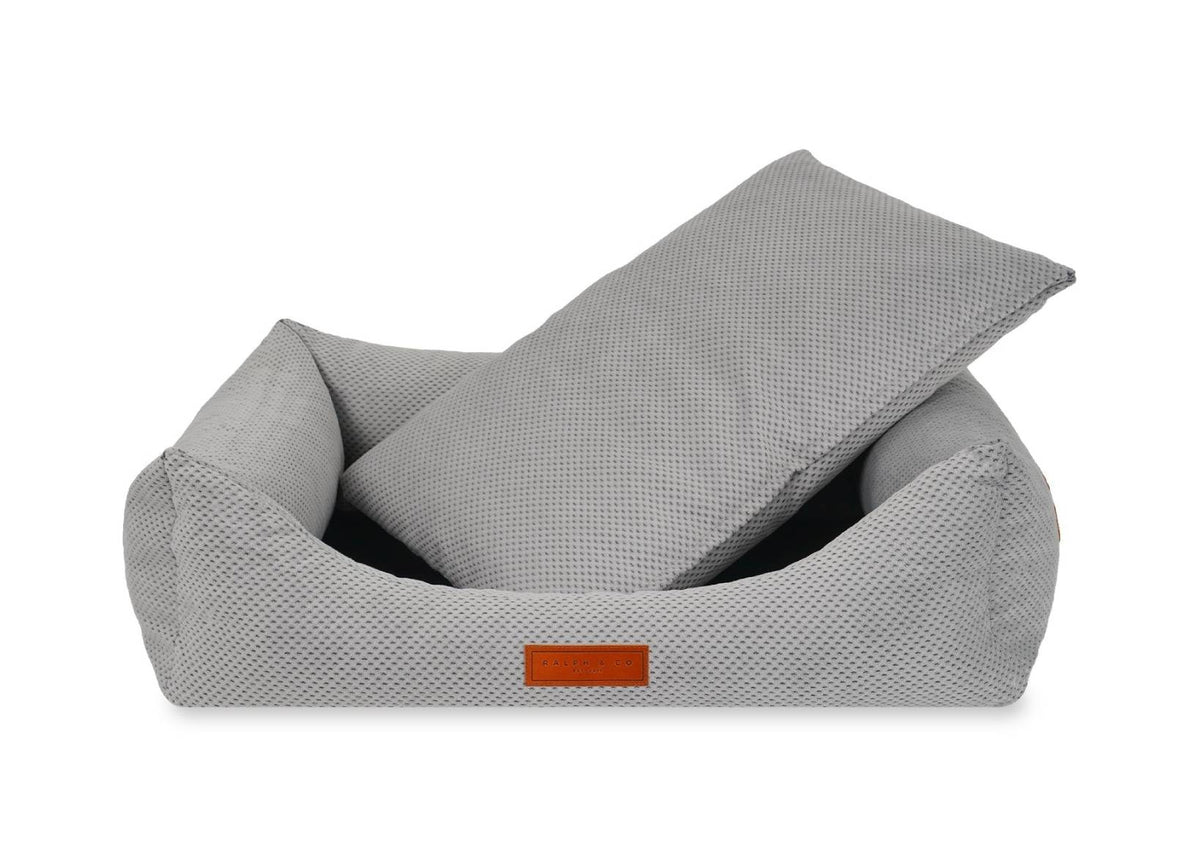 Gray bean bag chair with a small orange logo on a white background