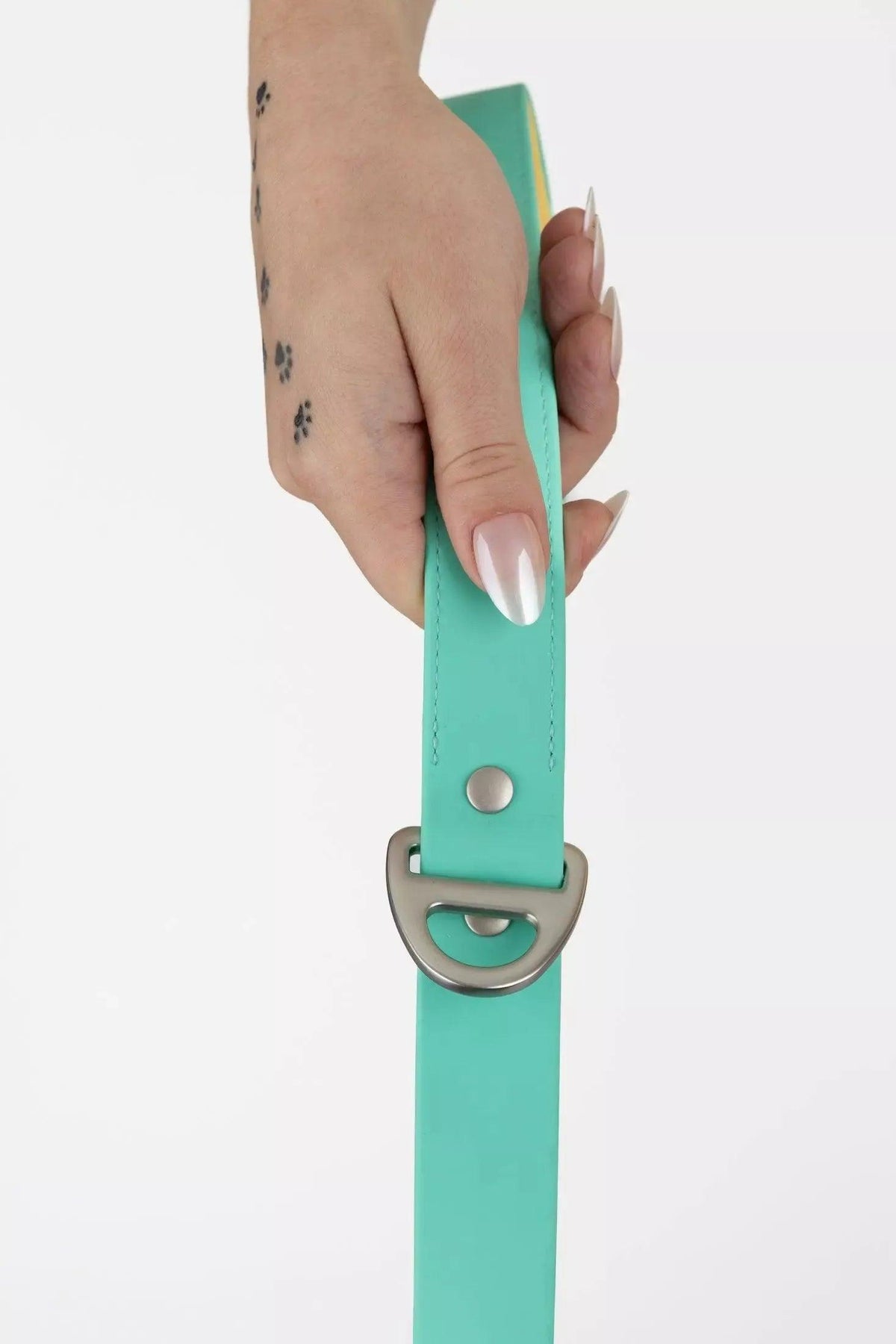 Hand holding a turquoise belt with a silver buckle on a white background