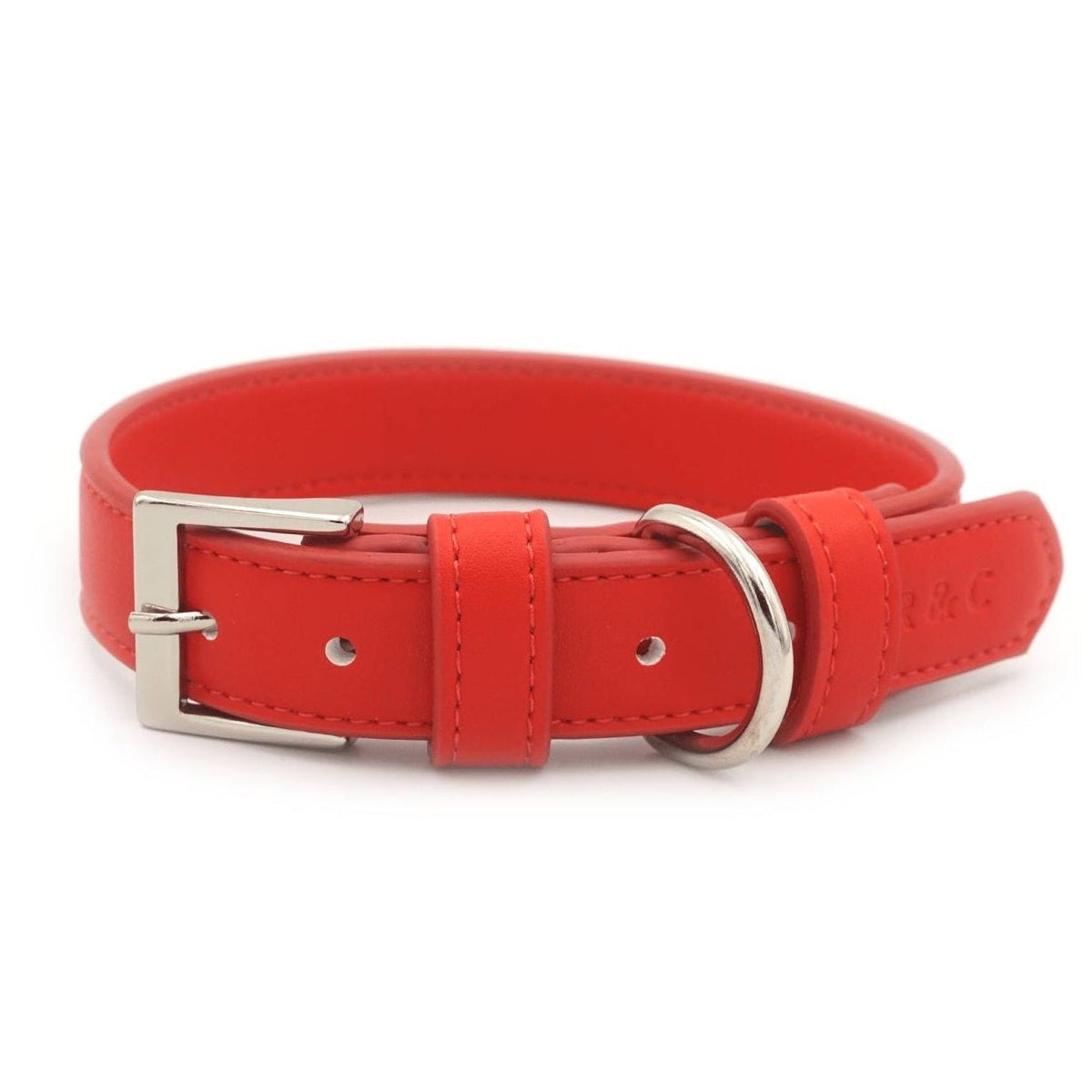 A bright red leather dog collar with a silver-tone metal buckle and D-ring, shown on a plain white background.