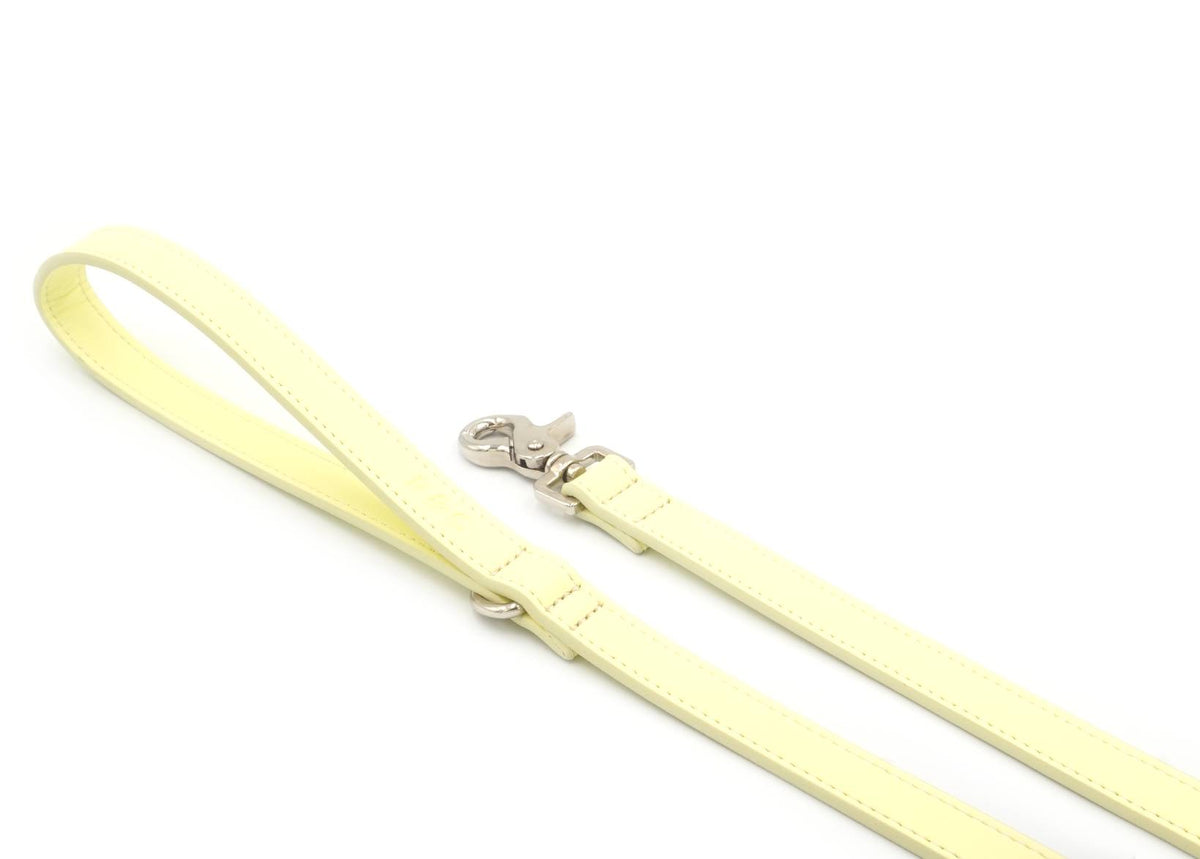 Yellow dog leash with a silver clip on a white background