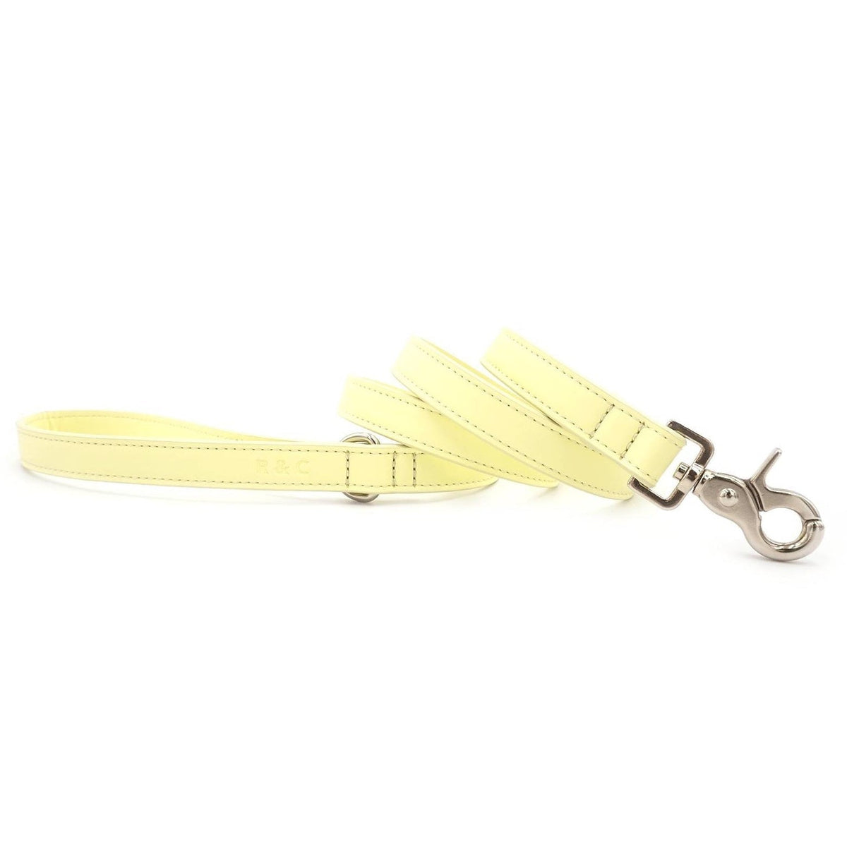 A pale yellow faux-leather dog leash with silver metal hardware, displayed on a clean white background.