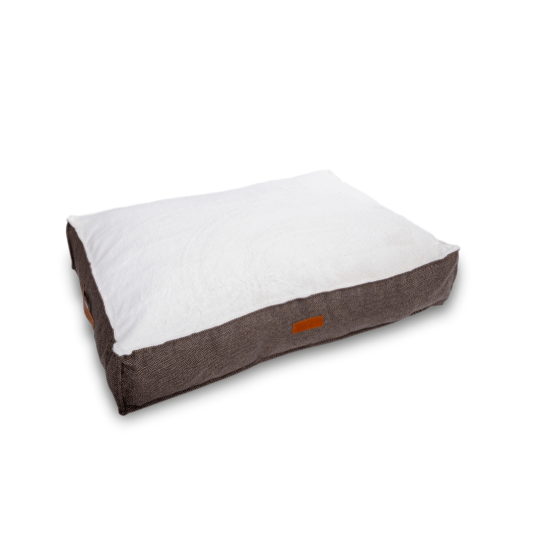 Dog bed with white cushion and brown exterior on a white background