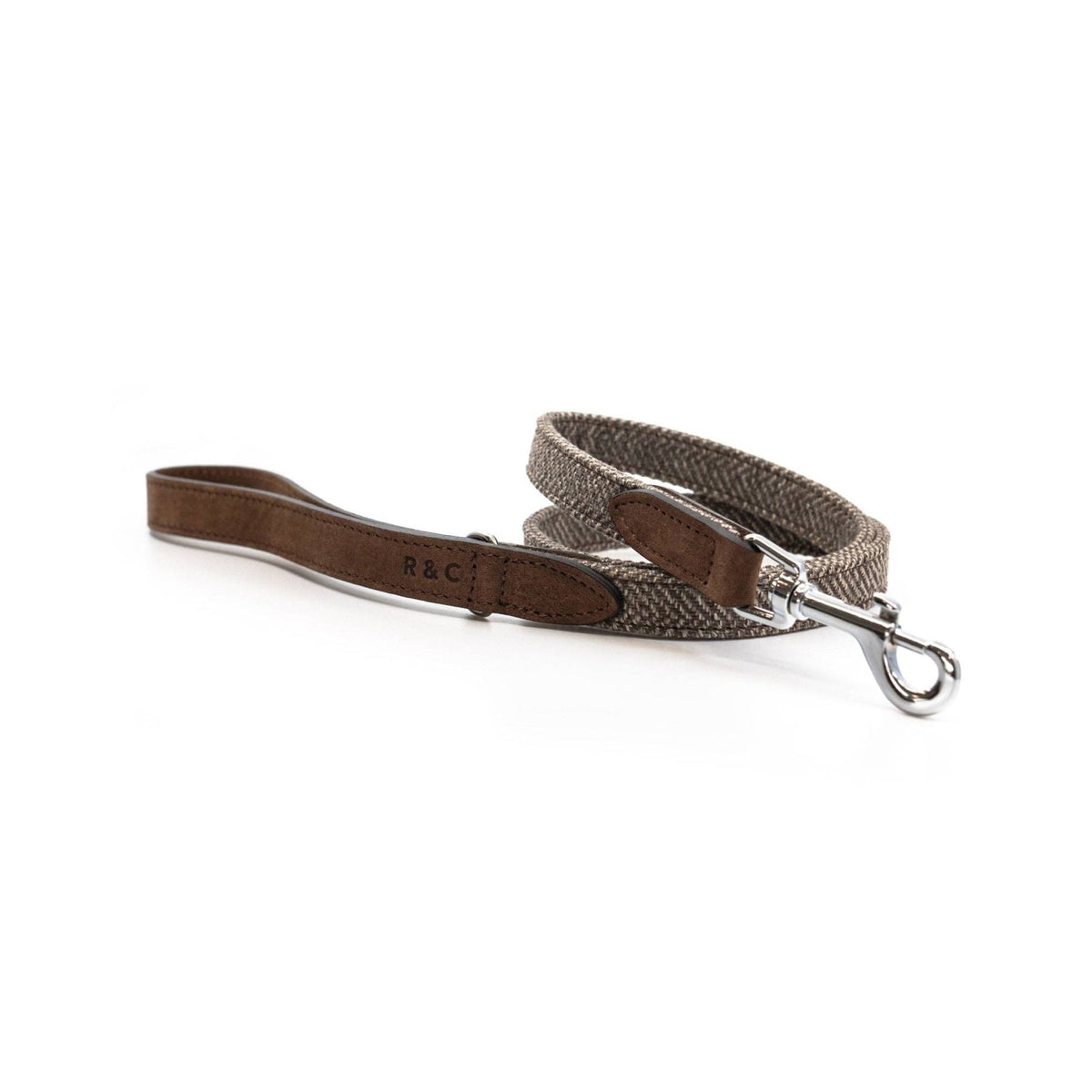 A brown leather dog leash with a silver metal snap hook and a woven brown and gray herringbone patterned strap, displayed on a clean white background.