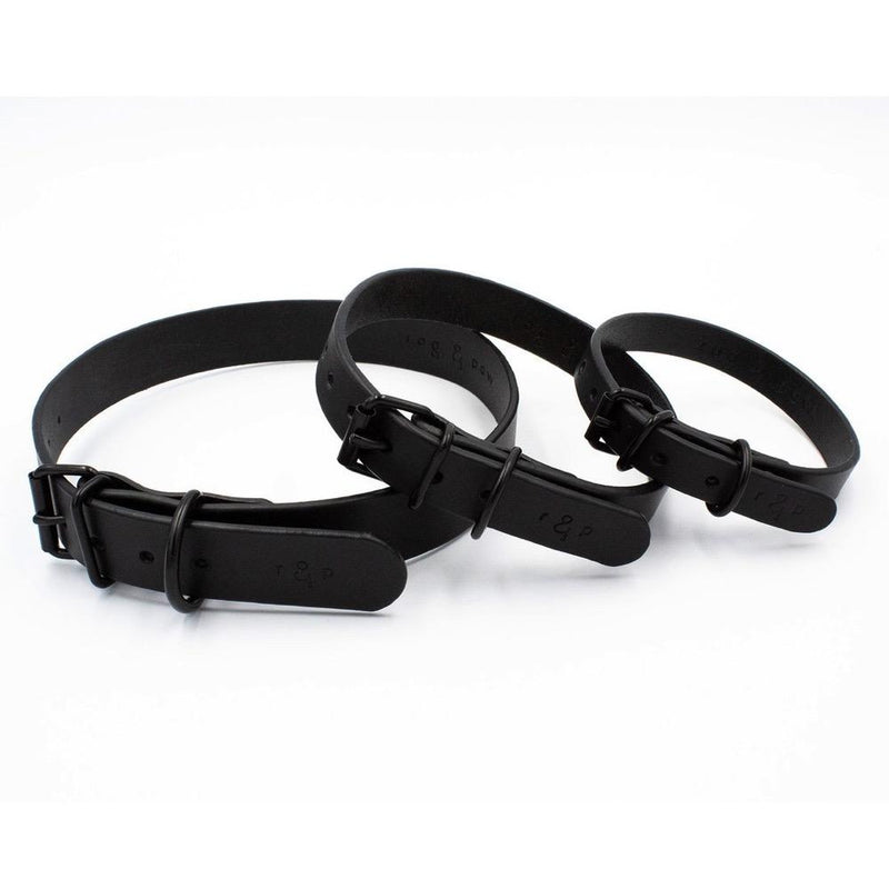 Three black dog collars on a white background