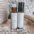 Two aromatherapy rollerball bottles on a wooden surface with lavender flowers.