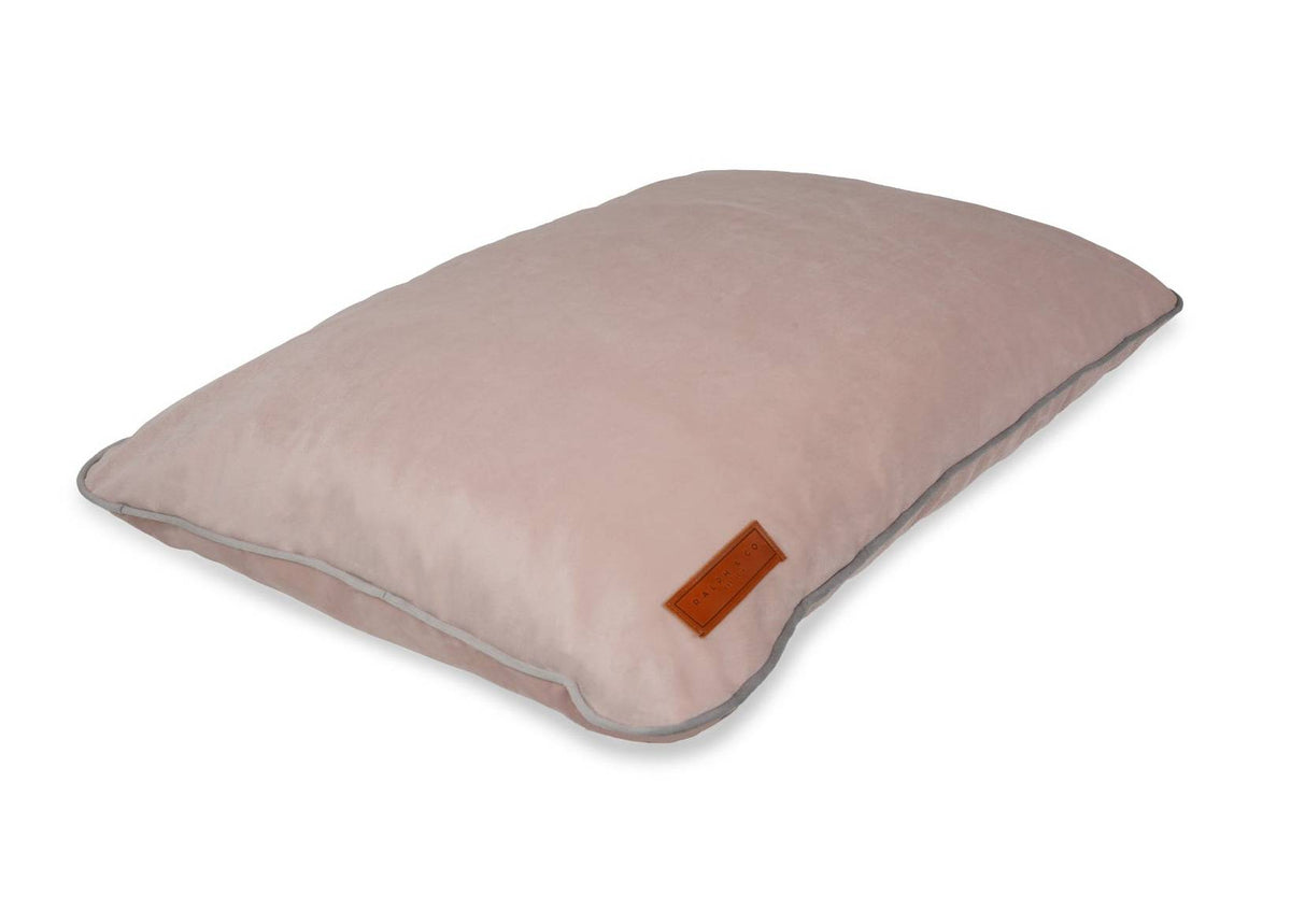 Pink pillow with a brown label on a white background