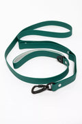 A green dog leash with a black carabiner clip and silver metal rivets, coiled on a white background.