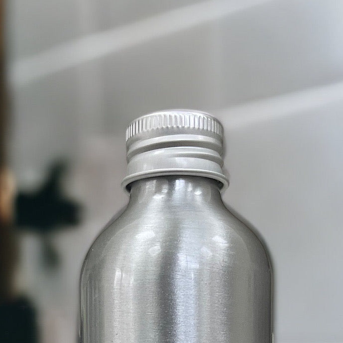 Silver bottle with a metallic cap on a blurred background